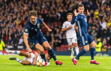 Glasgow, İskoçya, İngiltere - 6 Eylül 2019. İskoçya Millî Futbol Takımı oyuncuları Kenny McLean ve Charlie Mulgrew UEFA Euro 2020 ön eleme karşılaşmasında Rusya 'nın orta saha oyuncusu Ilzat Akhmetov' a faul yaptılar.
