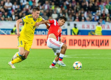 Kalininingrad, Rusya - 9 Eylül 2019. Kazakistan milli futbol takımı savunucusu Aibol Abiken UEFA Euro 2020 ön eleme karşılaşmasında Rusya 'ya karşı Kazakistan (1-0) karşısında Rusya orta saha oyuncusu İlzat Akmetov' a karşı Kalininingrad 'da oynanan karşılaşmada.