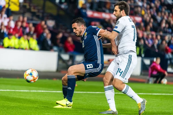Glasgow, İskoçya, İngiltere - 6 Eylül 2019. İskoçya Millî Futbol Takımı orta saha oyuncusu John McGinn UEFA Euro 2020 ön eleme karşılaşmasında Rusya 'nın defans oyuncusu Georgi Dzhikiya' ya karşı Glasgow 'da İskoçya-Rusya maçında.