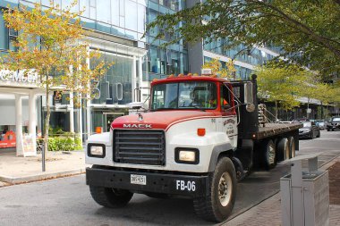 Baltimore, Maryland, USA  September 17, 2024: Vintage Mack truck driving the streets of downtown Baltimore. Framed by trees in early fall.