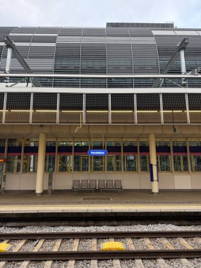 Viyana, Avusturya - 11 Ekim 2025: BB tren istasyonu Handelskai 'nin arka planında Rivergate ofis binasının metal levhaları bulunan boş platformu. Dikey.