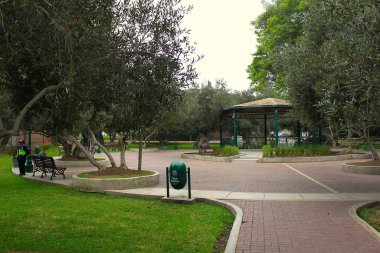 San Isidro, Lima, Peru - 24 Mayıs 2025: Zeytin ağaçlarıyla birlikte halk parkı Bosque El Olivar hem kültür mirası hem de eğlence alanıdır. Çardak ya da Prgola özel güvenlik tarafından ihtiyatlı bir şekilde korunuyor..
