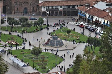 Cusco, Peru - 25 Mayıs 2025: Plaza de Armas 'ın Panorama manzarası veya Park' ın ortasında Altın İnka heykeli olan Plaza Mayor. Vatandaşlar ve turistler, yoğun araç trafiği.