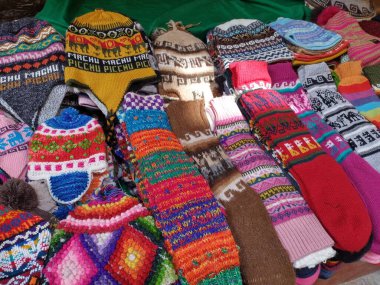 Aguas Calientes, Peru - 27 Mayıs 2025: Çorap ve chullos (kulaklıklar) gibi yün ürünlerden yapılan tipik Peru hatıraları. Sıcaklık ve canlı renklerden dolayı popülerdir. Geleneksel And dizaynı