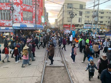 Juliaca, Puno, Peru - 28 Mayıs 2025: Ferrocarril del Sur 'da çıngırak sürüşü sırasında Perurail tarafından işletilen Titicaca treninin arka görüntüsü. Yollar boyunca işlek sokak ve pazar hayatı.