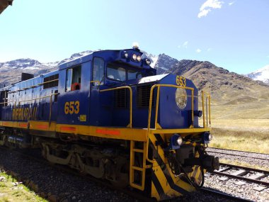 Cusco, Peru - 28 Mayıs 2025: Peru Demiryolu tarafından işletilen Titicaca treniyle La Raya sıradağlarının etkileyici panoramik manzarası. Ferrocarril del Sur. Lokomotif ALCO MLW Serisi C-26 DL-560D, No. 653.