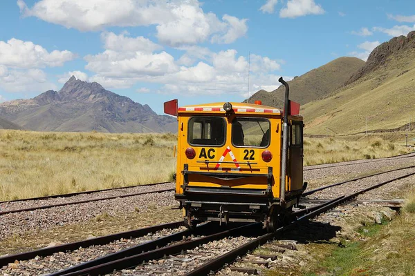 Cusco, Peru - 28 Mayıs 2025: Perurail 'in Öncü Otomobili Cusco' dan Puno 'ya giden normal bir yolcu treninin önünden geçiyor. Arka planda Khunurana dağ zirvesi karla kaplandı.