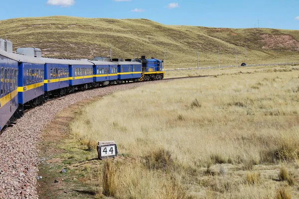 Puno, Peru - 28 Mayıs 2025: Perurail tarafından işletilen Titicaca treninin panoramik manzarası Andean dağ sırtı ile etkileyici Altiplano manzarasına doğru ilerliyor. Ferrocarril del Sur.