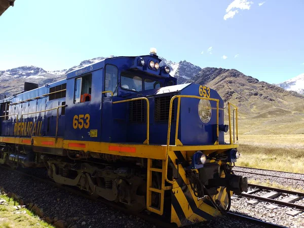 Cusco, Peru - 28 Mayıs 2025: Peru Demiryolu tarafından işletilen Titicaca treniyle La Raya sıradağlarının etkileyici panoramik manzarası. Ferrocarril del Sur. Lokomotif ALCO MLW Serisi C-26 DL-560D, No. 653.