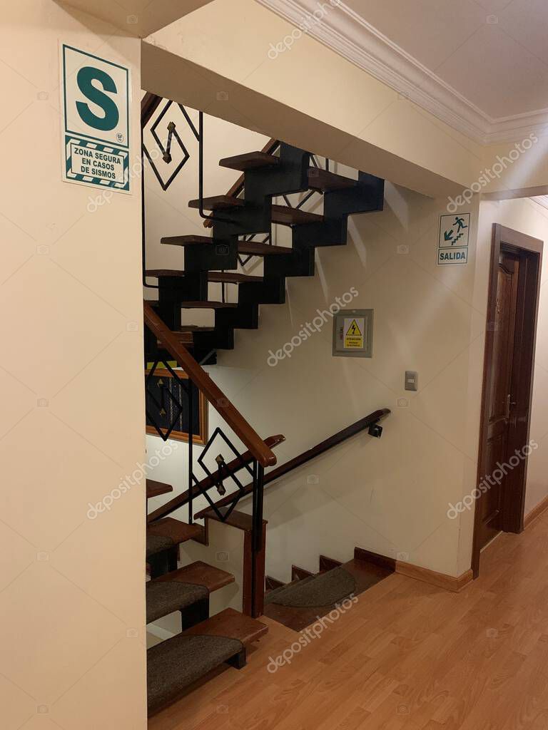 Cusco, Peru - May 25, 2025: Precautionary measures in public building: Signs indicating zona segura en casos de sismo (safe area in case of earthquake) and salida (exit) in staircase and corridor.