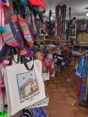 San Pedro de Atacama, El Loa, Antofagasta, Şili - Haziran 05, 2025: Tipik Şili hediyelik eşya dükkanının içi. San Pedro de Atacama Kilisesi ve bel çantasının parmak izleriyle dolu çanta..