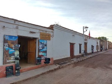 San Pedro de Atacama, El Loa, Antofagasta, Şili - Haziran 04, 2025: Asfaltsız yol, yaya yürüyüşü, restoranlar, dükkanlar ve butiklerle şehir merkezi manzarası. Tedarikçiler, turistler ve sokak köpekleri.