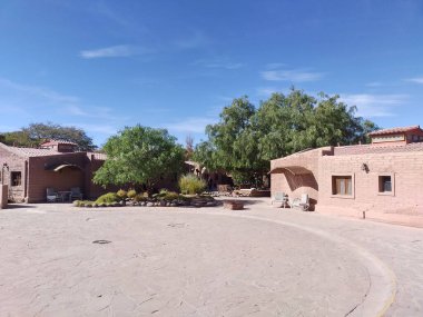 San Pedro de Atacama, El Loa, Antofagasta, Şili - Haziran 05, 2025: Hotel La Casa de Don Tomas 'ın ziyaretçi girişindeki araçlar için U dönüşü alanı. Yerleşim binaları ve bahçe ağaçları.