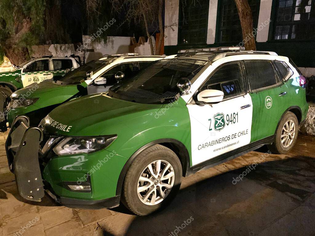 San Pedro de Atacama, El Loa, Antofagasta, Chile - June 04, 2025: Green white police patrol car of Carabineros de Chile parked at local police station. Metal mesh protects windows from thrown stones.