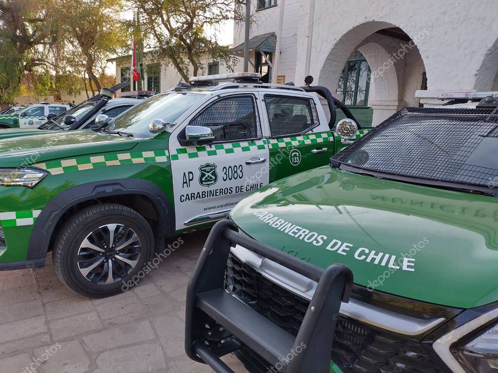 San Pedro de Atacama, El Loa, Antofagasta, Chile - June 04, 2025: Green white police patrol cars of Carabineros de Chile parked at local police station. Metal mesh protects windows from thrown stones.