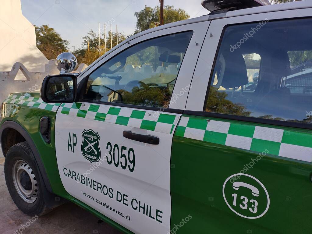 San Pedro de Atacama, El Loa, Antofagasta, Chile - June 04, 2025: Detail of right side and driver's door of green white police patrol car of Carabineros de Chile parked at local police station.