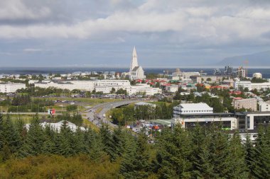 Reykjavik, İzlanda - 28 Ağustos 2015: Oskjuhlid tepesi ve Faxafloi körfezi 'nden volkanik dağ sırası Esja dağına kadar geniş açılı muhteşem panoramik manzara. Hallgrimskirkja görünür.