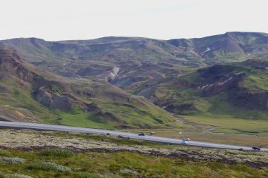 Skogar, Rangaring eystra, İzlanda - 29 Ağustos 2015: Hringvegur Çevre Yolu yakınlarındaki tepelerden yükselen jeotermal buhar bacalarıyla volkanik dağ manzarası. Uzak kutup doğası.