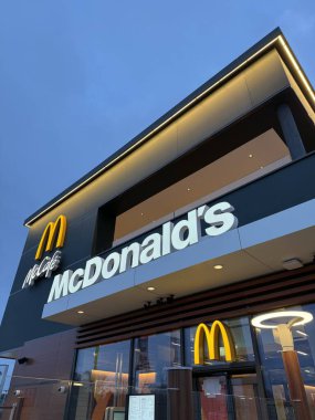 Gnserndorf, Aşağı Avusturya - 08 Şubat 2026: McDonald 's ve McCafe şubesinin gece açılı dış görünümü. Küresel fast food zincirinin modern ticari mimarisi.