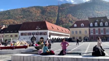 Brasov, Romanya - 23 Ekim 2025: Transilvanya 'nın Kronstadt kentindeki Yoğun Piata Sfatului (Konsey Meydanı). İnsanlar Tmpa Dağı 'nın altındaki şehir merkezinde ve Old Town Hall' da (Casa Sfatului)