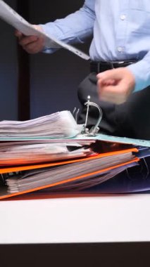 Dikey video Kişi, yumruklanmış belgeleri yerleştirmek veya kaldırmak, örgütü, bürokrasiyi temsil etmek ve yoğun bir ofis ortamında evrak işlerini yönetmek için bir halka klasörü açar