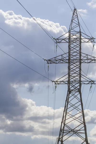 Linhas de transmissão de energia elétrica e pilão de eletricidade contra o céu azul. Vista de ângulo baixo — Fotografia de Stock