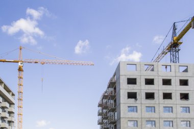 yüksek katlı bina inşaatı site Vinçler mavi gökyüzü ile