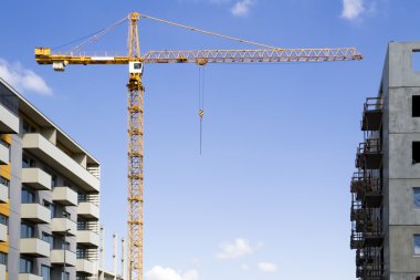 Mavi gökyüzü karşı Vinçler ile şantiye. Yeni yüksek binalar.