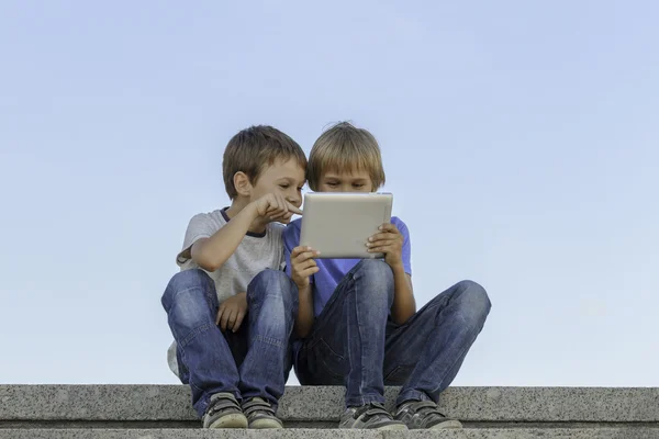 Dois meninos olhando para tablet pc. Infância, educação, aprendizagem, tecnologia, conceito de lazer — Fotografia de Stock