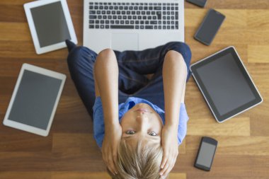Yorgun üzgün çocuk tabletleri, cep telefonları, dizüstü her yerde. Üstten Görünüm. Eğitim, öğrenme, teknoloji, bağımlılık kavramı