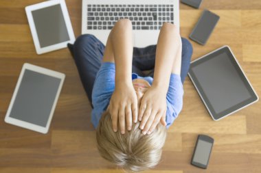 Tablet, cep telefonları, dizüstü her yerde üzgün çocuk evde yorgun. Üstten Görünüm. Eğitim, öğrenme, teknoloji, bağımlılık kavramı