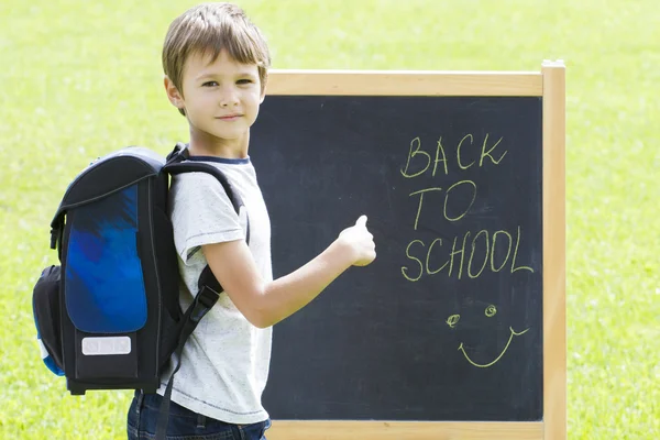 Kleiner Schüler gegen die Tafel. Bildung, zurück zum Schulkonzept — Stockfoto