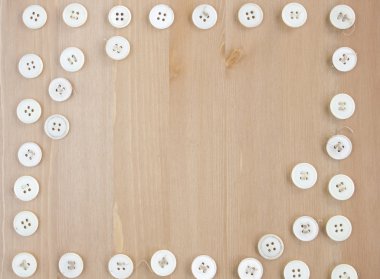 Ahşap arka plan üzerinde eski vintage düğmeleri dikdörtgen çerçeve kenarlığı.