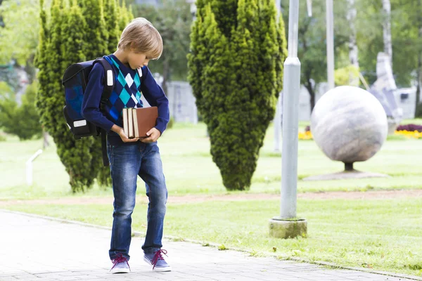 Niño con mochila y libros en sus manos. Exterior . — Foto de Stock