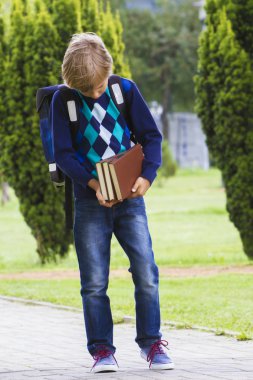 Çocuk kitapları onun elinde bakarak. Çocuk okula git. Açık.