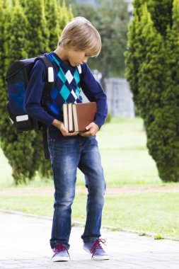 Sırt çantası yakaladığında ile çocuk elinde kitap. Açık.