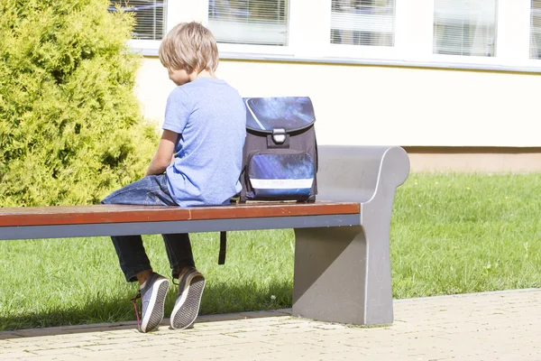 Λυπημένος, μοναχική, δυστυχισμένη, απογοητευμένοι αγόρι κάθεται μόνος κοντά στο σχολείο. Σακίδιο. Casual ρούχα. Εξωτερική — Φωτογραφία Αρχείου