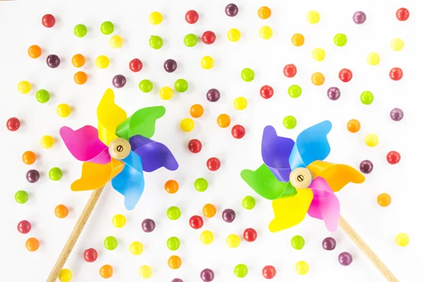 Colorful pinwheels and candies on white background. Top view. Flat lay — Stock Photo, Image