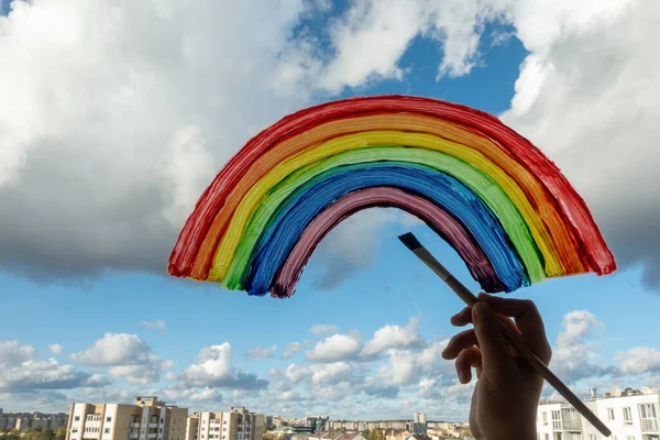 Kid mano pittura arcobaleno colorato sulla finestra durante la quarantena Covid-19 a casa. Rimanere a casa a causa del pericolo di infezione coronavirica. Simbolo di speranza — Foto Stock