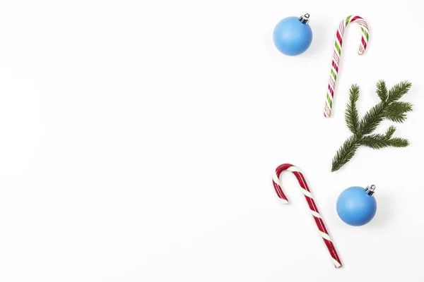 Fundo mínimo de Natal. Bengalas doces, pequena árvore de Natal e bolas de bugiganga de decoração azul de Natal no fundo branco. Vista superior — Fotografia de Stock