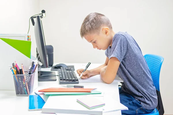 ビデオ通話を持つコンピュータを持つ10代の少年,仮想オンラインレッスン,自宅で宿題を作る — ストック写真