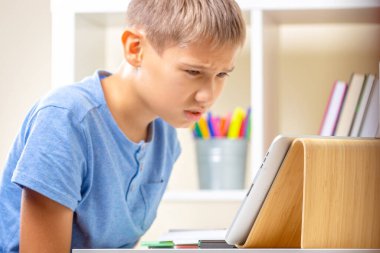 Confused upset teenage boy stuck with homework. Kid having learning problem. Learning difficulties, online education concept clipart