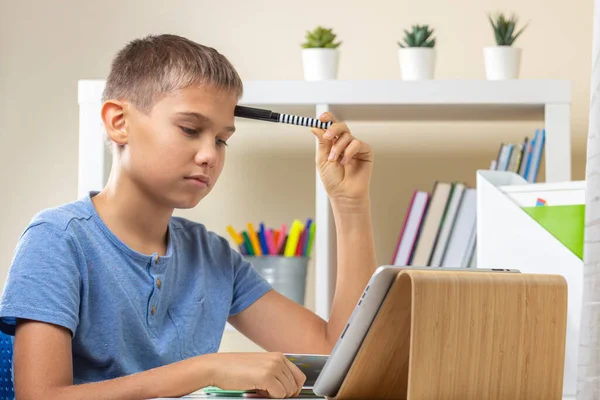 Adolescente com computador tablet digital pensando, fazendo lição de casa, ter aula on-line em casa — Fotografia de Stock