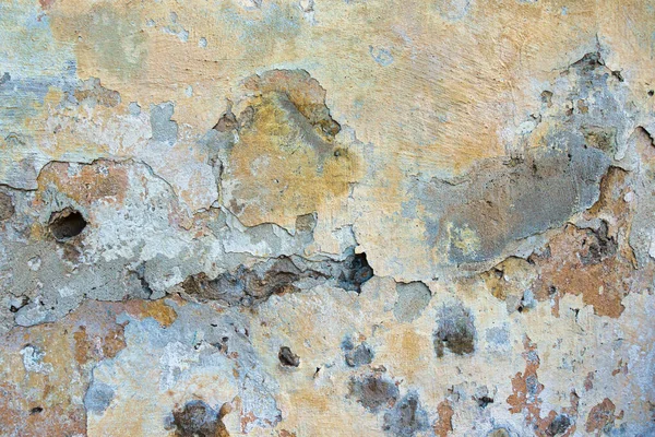 Old cracked weathered painted wall background texture. Light peeled plaster wall with falling off flakes of paint — Stock Photo, Image