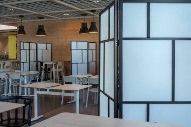 Boş bir kafe. Yeni normal sosyal mesafe. Boş masalar ve kalkan bölmeli koltuklar Coronavirus covid-19 salgınını azaltıyor.