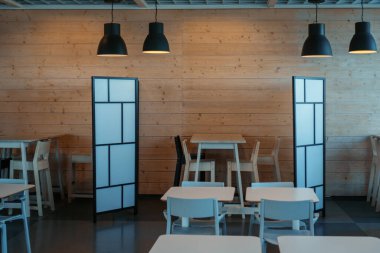 Boş bir kafe. Yeni normal sosyal mesafe. Boş masalar ve kalkan bölmeli koltuklar Coronavirus covid-19 salgınını azaltıyor.