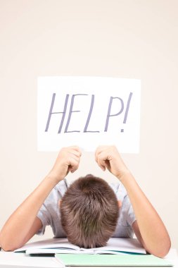 Öğrenme güçlüğü, okul, eğitim, çevrimiçi uzaktan öğrenme kavramı. Dizüstü bilgisayarı olan üzgün çocuk yardım sözcüğüyle kart tutuyor.