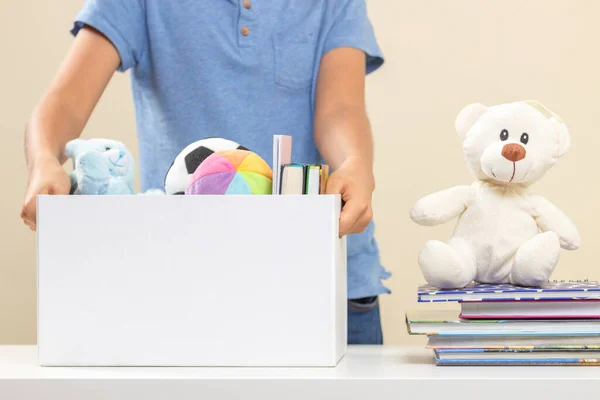 おもちゃ、服、本、募金箱をテーブルの上に並べ替えるボランティア — ストック写真