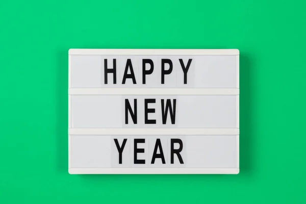 Новогодний текст в светлой коробке на зеленом фоне — стоковое фото