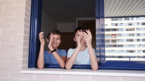 Bambini che applaudono dalla finestra per sostenere medici, infermieri, operatori ospedalieri durante la quarantena pandemica di Coronavirus — Video Stock